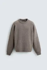 Jersey de punto con textura efecto pelo, corte boxy fit, cuello redondo y manga larga con acabados en rib.
