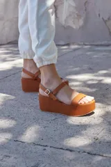 Sandalias color marrón con plataforma y tira ancha sobre los dedos.