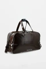 Bolso de fin de semana tipo duffel en material efecto charol color azul marino. Presenta doble asa superior con detalle en verde, correa ajustable extraíble con logo, cierre principal con cremallera y ribetes en contraste blanco. Incluye el nombre de la marca estampado en la parte frontal.