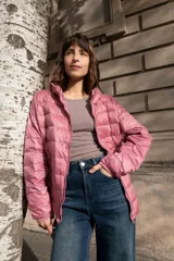 Campera puffer ultraliviana color beige, con diseño acolchado horizontal, capucha incorporada, cierre frontal y bolsillos laterales.
