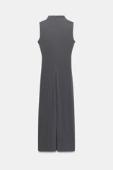 Vestido midi negro con cuello subido y diseño sin mangas (sisa). Presenta un elegante detalle de tejido drapeado en el lateral y cierre trasero con cremallera oculta.