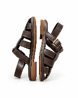 Sandalias Loop de cuero genuino color negro, con diseño de tiras entrelazadas, tira trasera y hebilla metálica.