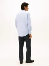 Camisa de vestir de manga larga, color celeste con rayas verticales blancas, cuello clásico y pequeño logo bordado en el pecho.