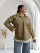 Buzo beige de ecocuero con cuello polo y cierre metálico parcial.