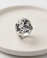 Anillo de acero de diseño amplio con patrón geométrico esmaltado en tonos blancos, negros y grises, y detalles de nácar.