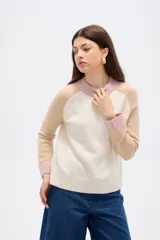 Sweater de punto con diseño color block, presenta cuerpo en color rosado, mangas en azul marino y detalles de cuello y puños en color verde oliva. Posee un corte holgado y cuello redondo a la base.