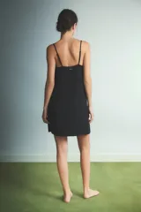 Camisón corto de color negro con breteles finos y detalle de encaje blanco en el escote en V.