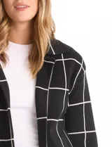 Cardigan de tejido de punto con diseño de cuadros, cuello con solapa y abertura frontal. Presenta un corte recto y mangas largas.