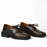 Zapato acordonado de cuero vacuno con acabado desgastado, de horma cuadrada y suela de goma con pequeño taco.