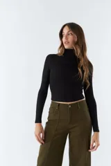 Polera negra de cuello alto y manga larga, de corte ajustado.