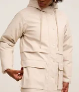 Campera parka de Marfinno confeccionada en PU con textura gomosa, color beige. Cuenta con capucha, forro interior de peluche sintético, cierre frontal con solapa y botones a presión, y bolsillos delanteros grandes con solapa.