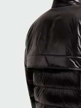 Campera corta acolchada de Moncler, modelo Orres, en color negro con acabado brillante. Presenta cuello alto, cierre frontal completo y dos bolsillos verticales con cierre en el pecho. Cuenta con puños elásticos y diseño técnico de la línea Grenoble.