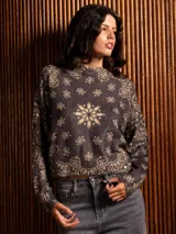 Buzo de punto de manga larga con cuello redondo, confeccionado en un tejido suave de textura peluda. Presenta un diseño estampado con motivos florales y ornamentales en color negro sobre una base de color rojo intenso.