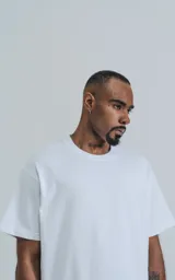 Remera de corte boxy con silueta amplia y recta, confeccionada en algodón premium. Presenta cuello redondo y mangas cortas con un calce relajado.