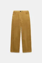 Pantalón de tiro medio confeccionado en tejido de pana, con diseño de pierna ancha, bolsillos delanteros y traseros, y cierre frontal con cremallera y botón.