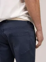 Pantalón de gabardina de corte slim fit y tiro medio, con diseño de cinco bolsillos y cierre de cremallera.