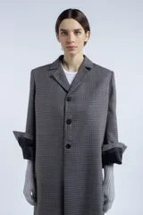 Tapado largo de lana virgen con motivo pied de poule, cuello con solapa y cierre frontal con tres botones.