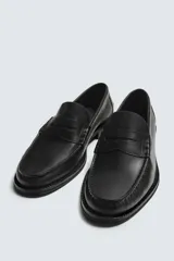 Mocasín de vestir fabricado en piel color marrón oscuro, con detalle de antifaz en el empeine, plantilla de piel y suela a contraste con ligero tacón.