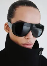 Abrigo largo de paño en color negro, con diseño de doble botonadura, cuello alto y corte estructurado.