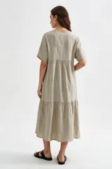 Vestido midi marrón de corte holgado, con escote en V, mangas cortas y detalle de volados fruncidos en el pecho y en el ruedo.