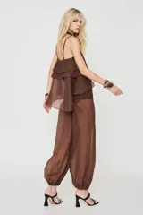 Blusa marrón sin mangas con tirantes finos, escote en V y diseño escalonado de volados con cintura elástica fruncida.