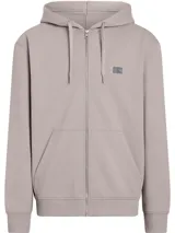 Buzo Calvin Klein con capucha y cremallera, color lila, de corte relaxed, con bolsillos laterales, puños y dobladillo con punto canalé y parche con logo en el pecho.