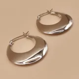 Aros tipo argolla de diseño ancho y superficie lisa con acabado brillante, fabricados en plata 925.