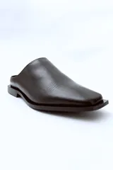 Mocasín negro de cuero con punta cuadrada y talón descubierto.