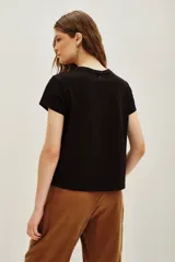 Remera negra de algodón con estampa frontal de un tigre realizada con aplicaciones de cuentas y bordados. Presenta mangas cortas con dobladillo y corte holgado.