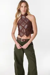 Top halter negro confeccionado con una mezcla de cuero y tejido artesanal, con diseño geométrico de rombos unidos por costuras de crochet y dobladillo en punta.