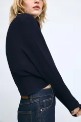 Jersey de punto color mostaza con escote en pico y manga larga con puños ajustados.
