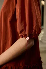 Vestido corto azul marino de corte suelto y silueta evasé, con cuello redondo, mangas cortas con regulador ajustable y detalle de volado fruncido en la parte inferior.
