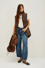 Trench color marrón con capucha, cierre frontal, cordón ajustable en la cintura y bolsillos laterales. Incluye un chaleco interior con estampado animal print.