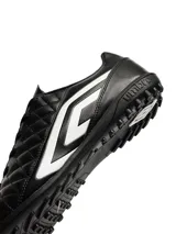 Championes de fútbol Umbro modelo Nexus TF, color negro con detalles en blanco. Presentan una superficie acolchada con costuras en forma de diamante y suela con tapones pequeños ideales para césped sintético.