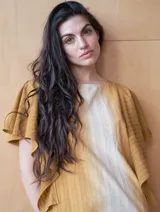 Vestido midi con estampado a rayas verticales en tonos verde oliva, gris y blanco. Tiene cuello redondo y mangas cortas amplias tipo volado.