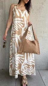 Vestido largo color beige con estampado de hojas blancas, de tirantes finos y corte recto.