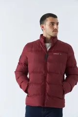 Campera puffer color bordó, con cuello alto y cierre frontal. Tiene bolsillos laterales con cierre y logo estampado en el pecho.