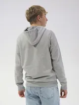 Campera deportiva unisex color beige, confeccionada en algodón con felpa, con capucha, cierre frontal y bolsillo tipo canguro.