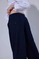 Pantalón de tiro medio y piernas anchas, confeccionado en mezcla de lino y algodón, con bolsillos delanteros y traseros con detalles de costuras pespunteadas a contratono.