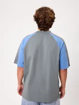 Remera holgada Rusty modelo Isel, de diseño bicolor con cuerpo azul marino y mangas ranglán blancas. Cuenta con cuello redondo ribeteado y pequeño logo bordado en el pecho.