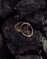 Brazalete rígido abierto de metal color plateado con textura irregular.