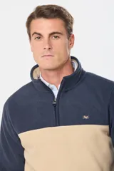 Buzo de polar bicolor azul marino y verde con medio cierre y bolsillos laterales con cierre.