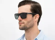 Lentes de sol INVU con montura cuadrada negra y lentes polarizadas grises.