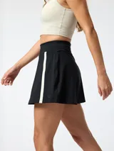 Skort deportivo negro con short interior integrado, cintura alta y franjas verticales blancas en los laterales. Confeccionado con tecnología Aloe Vera.