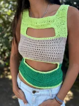 Top corto tejido de punto a crochet, sin mangas, con diseño multicolor en celeste, beige y azul, y aberturas frontales estratégicas tipo cut-out.