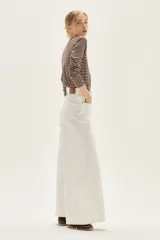 Jean de mujer color blanco, tiro alto, con pierna ancha y corte acampanado. Presenta costuras verticales marcadas en el frente de las piernas.