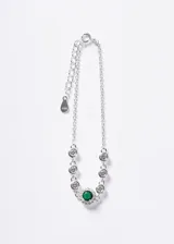 Pulsera de plata 925 con cadena eslabonada, decorada con circonias blancas en chatón y una piedra central redonda de color verde rodeada de un halo de circonias más pequeñas. Incluye cadena de extensión.