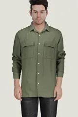 Camisa verde oliva de manga larga con cuello clásico, cierre frontal con botones y dos bolsillos de parche en el pecho.