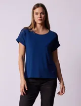 Remera combinada blanca, marca Rio & Rian, con cuello a la base y mangas cortas con aplique calado y broderie.