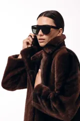 Tapado corto de piel sintética en color marrón chocolate, con cuello solapa amplio y cierre frontal oculto. Presenta una silueta estructurada y elegante.